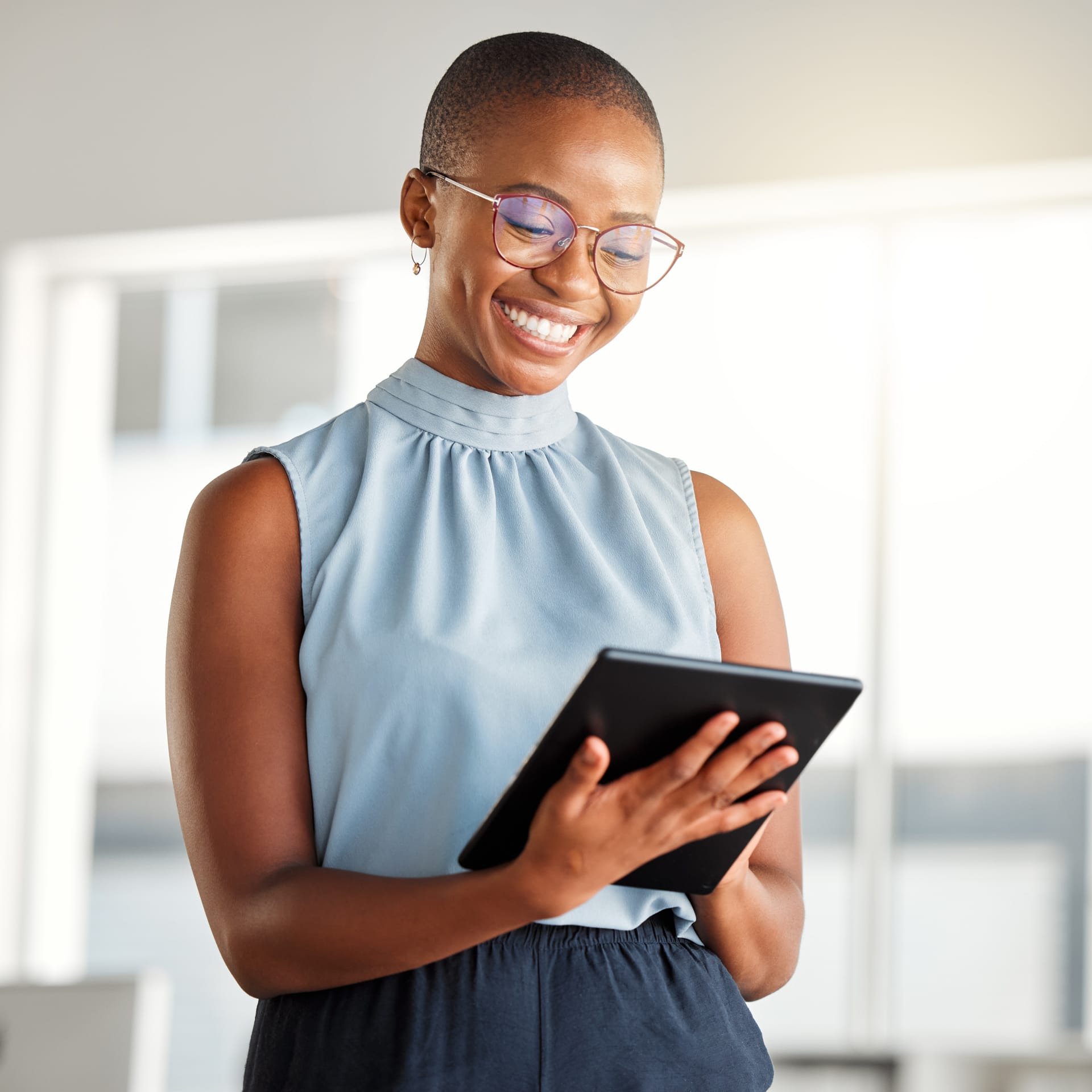 Young professional smiling at a tablet
